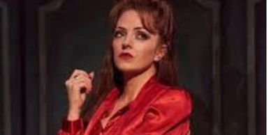 Woman in red blouse posing confidently.