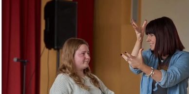 Two women communicating, one using sign language.