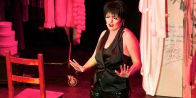 Woman performing on stage in black outfit.