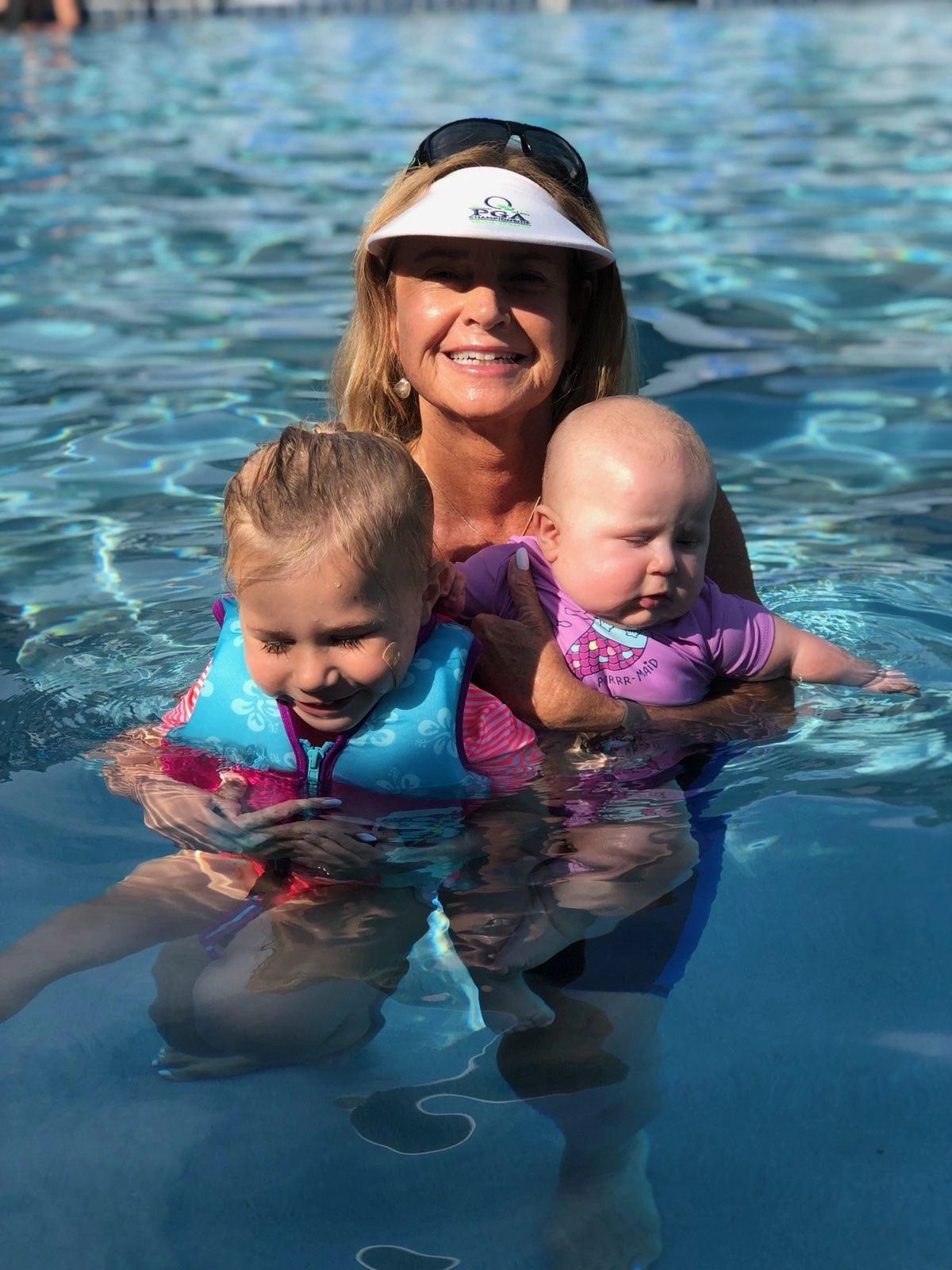 A 4 month old baby and her 3 year old sister at swim lessons.