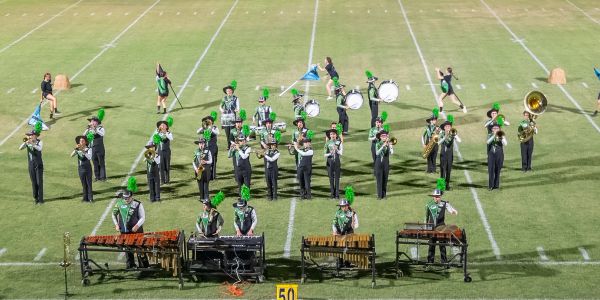 Marching band performing on football field.