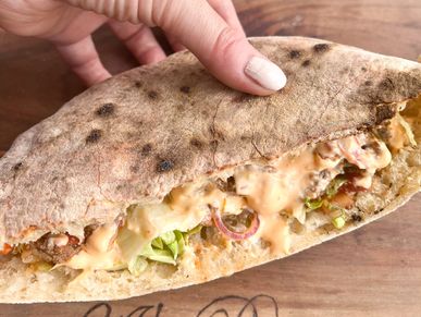 Pita Bread filled with beef (taco), lettuce, bell peppers, onions, burger sauce.