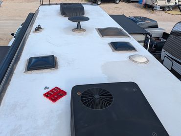 Rooftop of an RV with vents and a toolset placed on it.