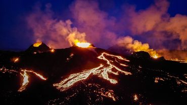 Night picture of three volcano erupting in the background