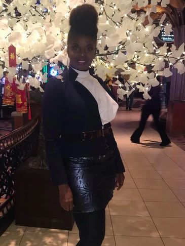 Woman in black and white outfit posing indoors.