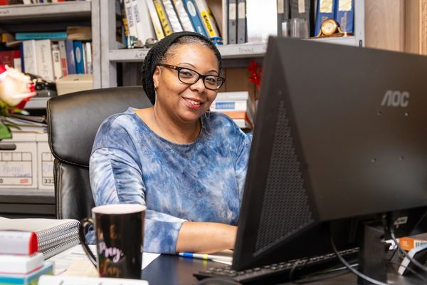 A woman is sitting near her computer