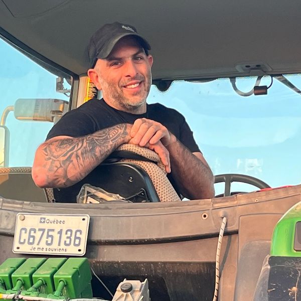 Jean-François Légaré posant fièrement assis dans son tracteur vert