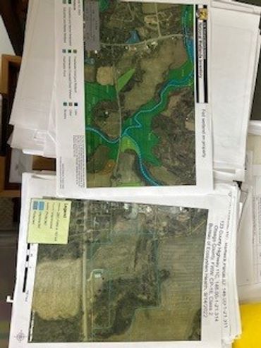 Aerial maps showing land and water features on printed papers.