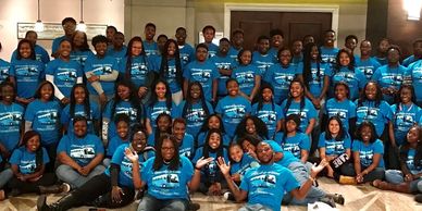 A group of people wearing blue 4 Knowledge Is Power Inc. shirts