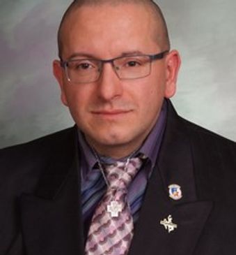 headshot of a man with specs