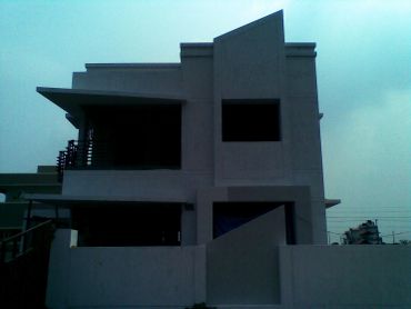 Modern two-story house with minimalistic design and large windows.