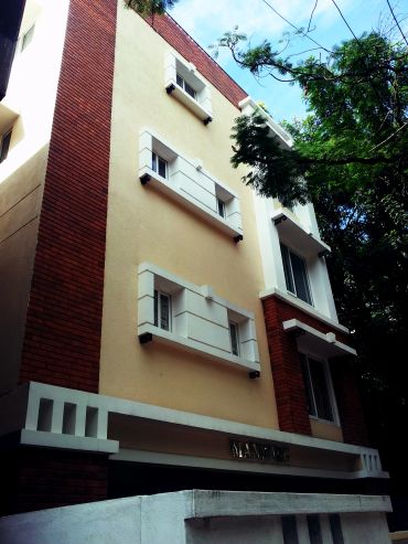 Modern building facade with brick and cream walls under a blue sky.