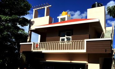 Modern house with water tanks on the roof under a clear blue sky.