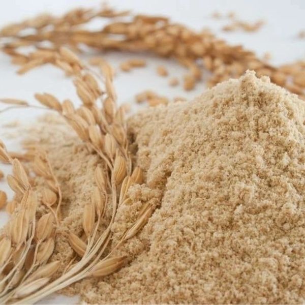 Pile of whole wheat flour with wheat stalks.