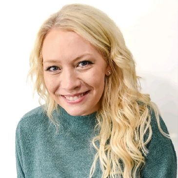 Smiling woman with long blonde hair wearing a teal sweater.