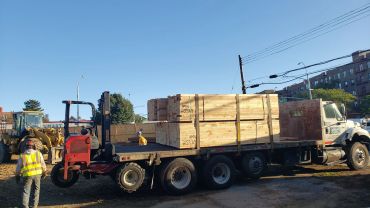 Truck loaded with large wooden crates in outdoor area.
