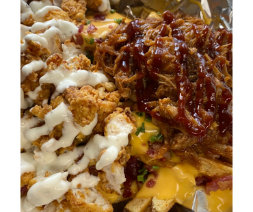 Loaded fries topped with fried chicken, shredded BBQ pork, cheese, ranch, and chives.