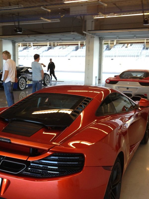 3 Exotic cars in a garage parked waiting to go on track