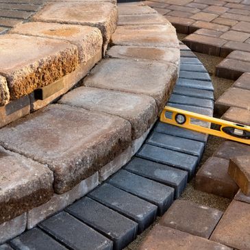 Close-up of a circular stone step under construction with a level tool.