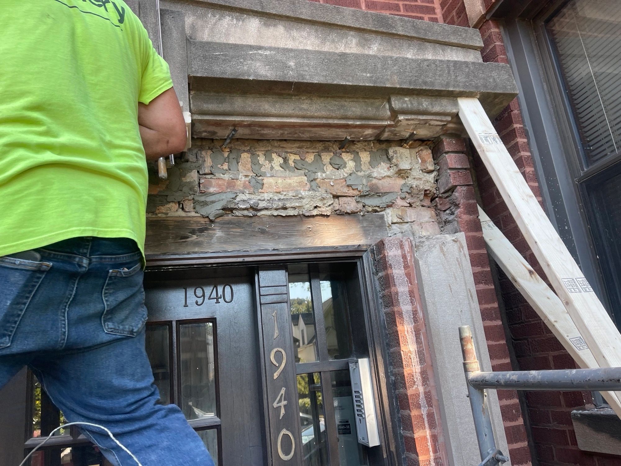 Close-up of damaged brickwork and lintel repair above a front door.