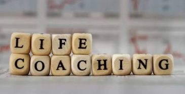 Wooden blocks spell out 'Life Coaching' on a blurred background.