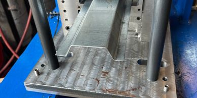 Metal forming tool with U-shaped channel on platform.