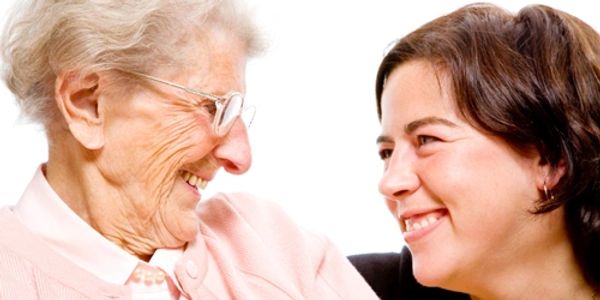 Elder and carer smiling at each other