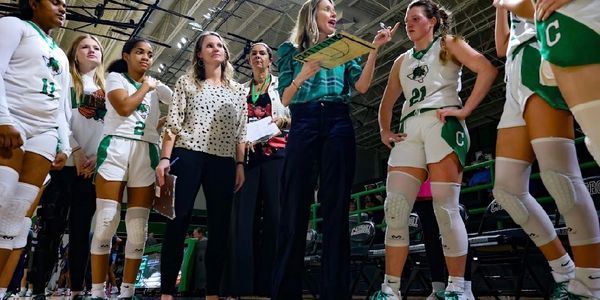 Women basketball team in discussion during a timeout.