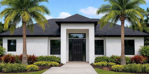 Modern house with palm trees and a clear blue sky.