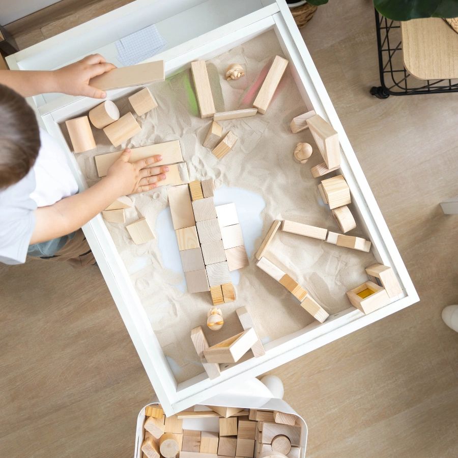 Child playing with blocks and sand - Sandtray Therapy in Calgary