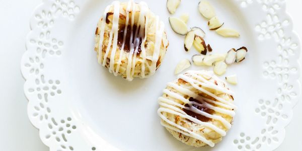Abrikozen-Bitterkoekjes Dutch chewy almond cookies with apricot jam on lace plate with sliced almond
