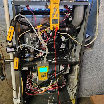 about us a photo of a furnace being serviced/repaired
