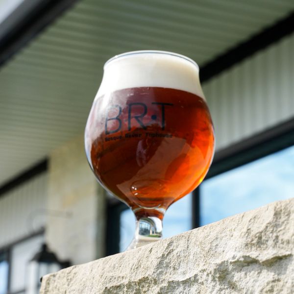 Glass of amber beer with foam on top.