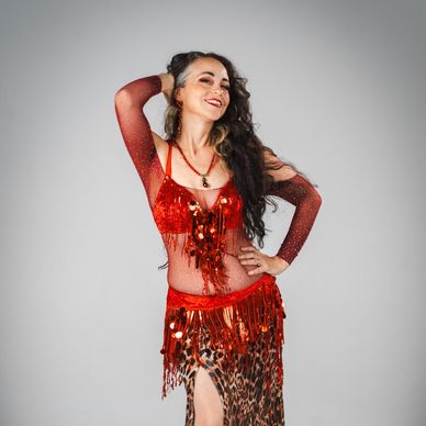 Woman smiling in a sparkling red and leopard print dress.