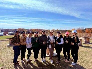 A group of women enjoying drinks outdoors on a sunny day.