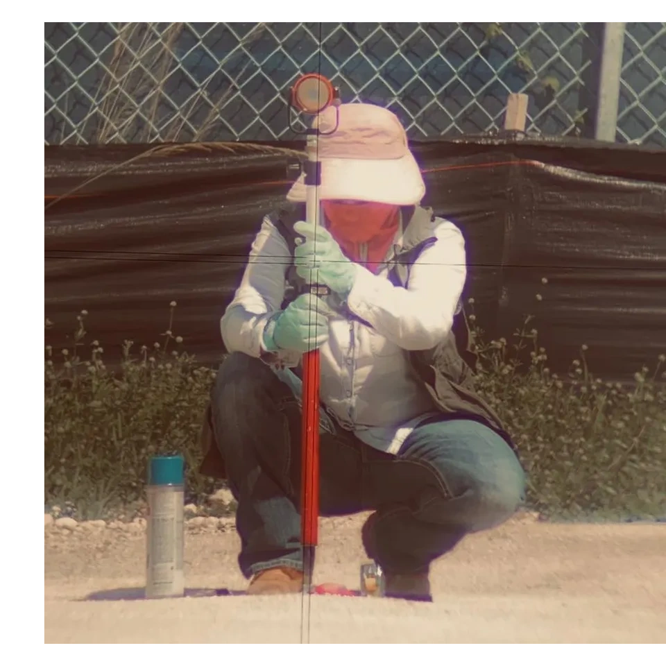 Female surveyor holding a prism for a construction stakeout.