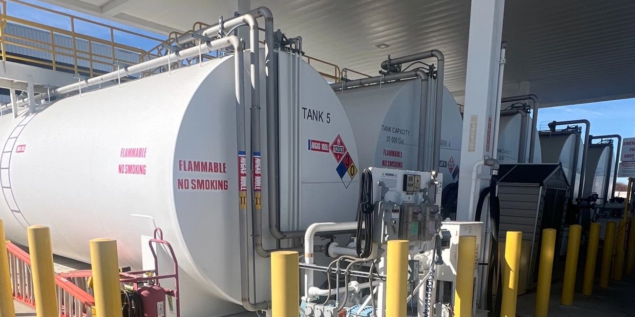 Large white tanks labeled flammable and no smoking at an industrial site.