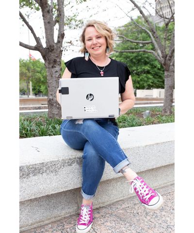 Michelle Risser, LISW-S, maternal mental health and trauma therapist sits with a laptop.