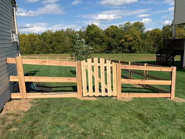 three board poplar fence with a treated arch gate