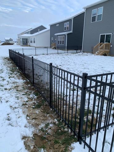 Custom black aluminum fence installed in winter