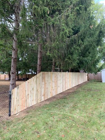 treated privacy fence that staggers down from six foot tall to four foot tall