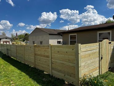 horizontal treated privacy fence with a arched gate