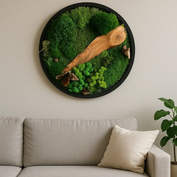 Moss wall art, round with black frame on a light gray wall, a modern gray sofa with a cream pillow