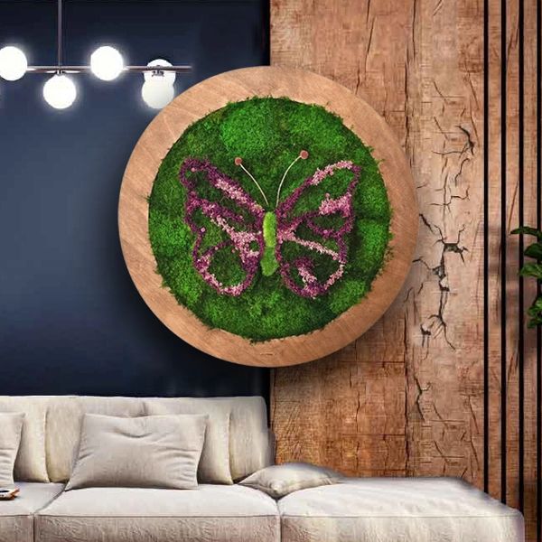 A round piece of wall art depicts a butterfly made of preserved moss with pink and purple flower acc