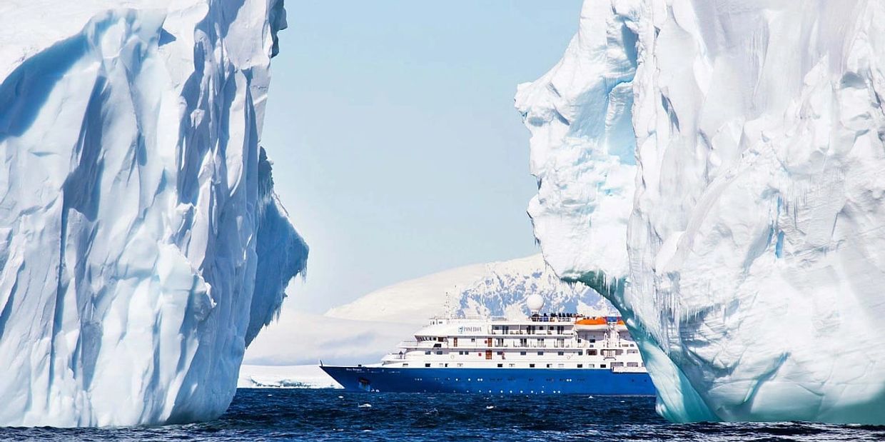 Cruise ship between two icebergs in Antarctica.