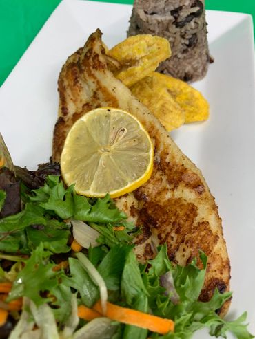 White fish fillet with mixed green salad, dirty rice and tostones.