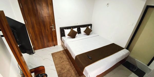 Minimalist bedroom with white walls, brown accents, and modern furnishings.
