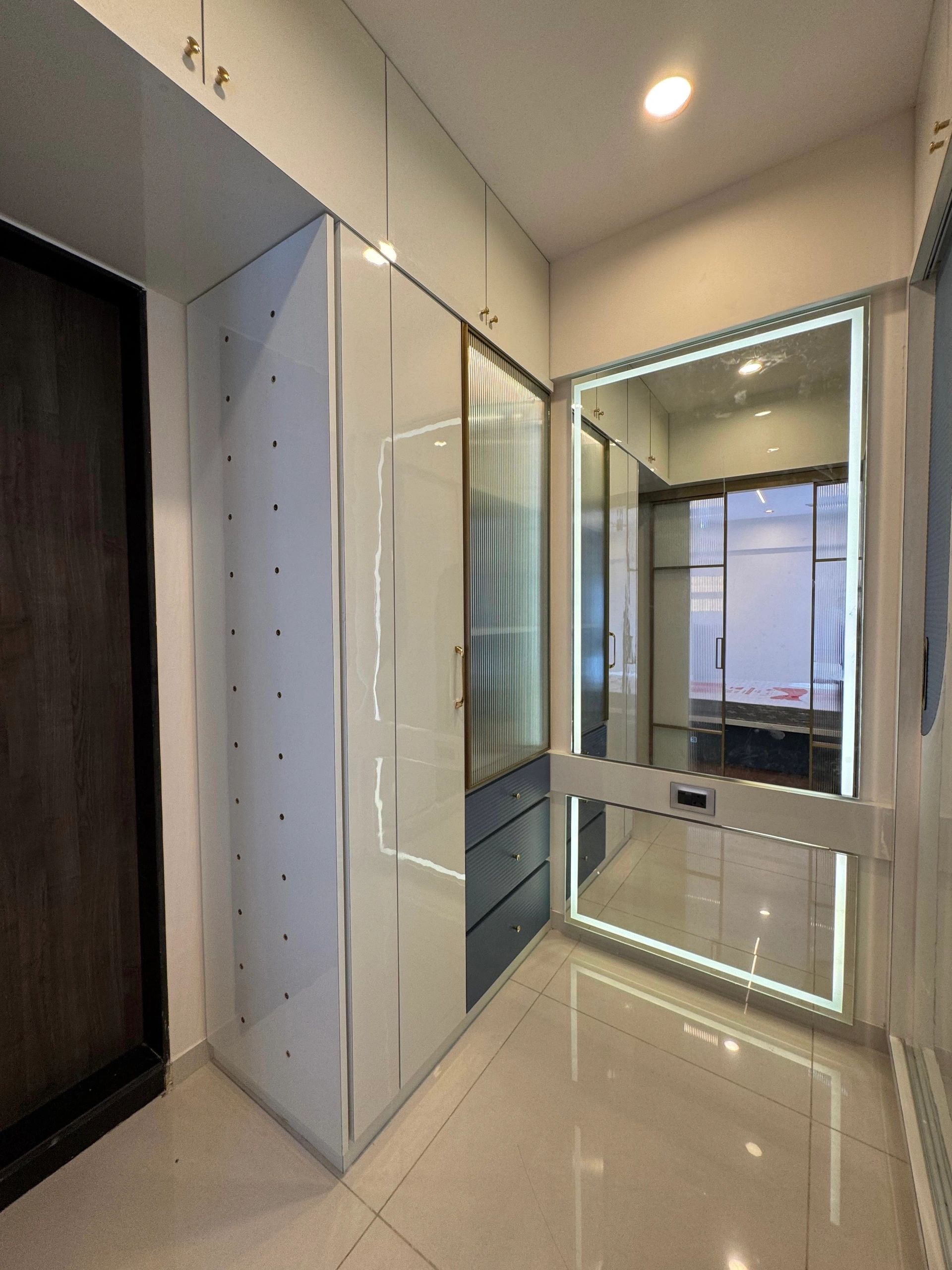 Sleek modern hallway with built-in storage and illuminated mirror.