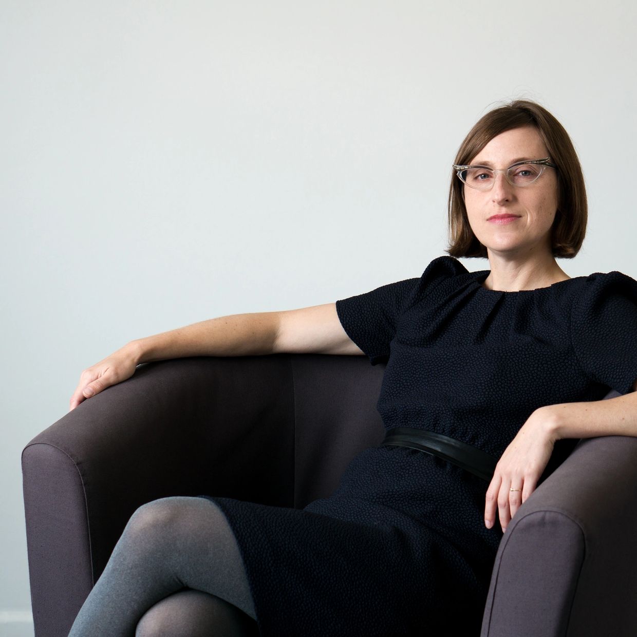 Woman with short brown hair, cat eyeglasses, in a relaxed pose. Photo credit: Ilme Vysniauskaite.