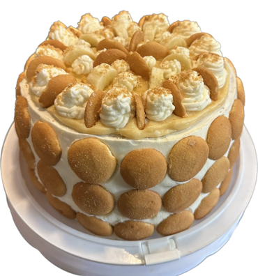 Banana pudding cake decorated with vanilla wafers and whipped cream.